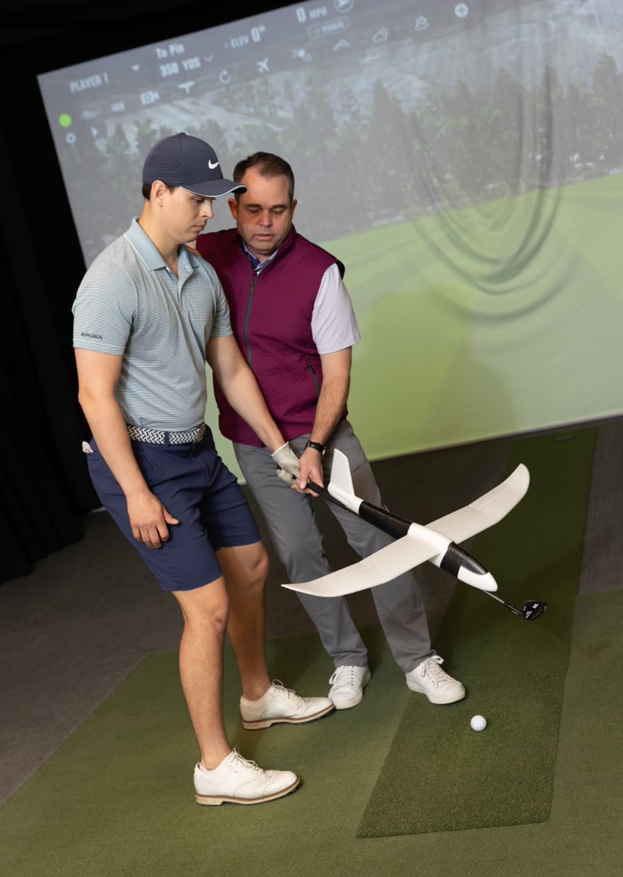 Rick Silva teaching a young player using an airplane-wing training tool