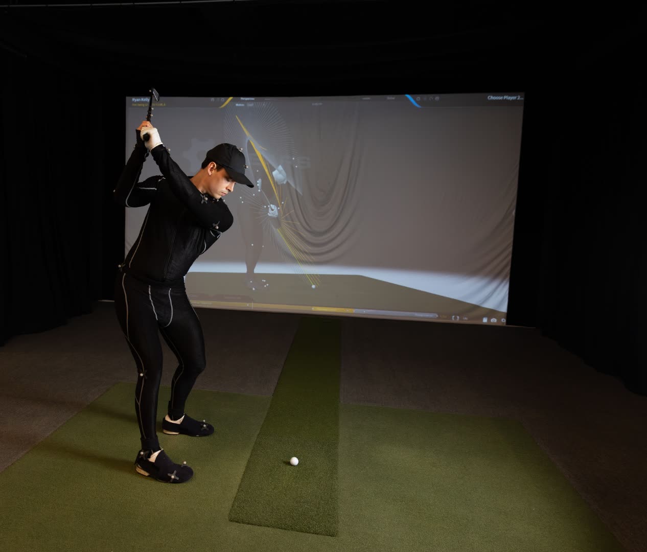 Athlete in a motion-capture suit mid-swing in front of a GEARS 3D projection at Movement 3 Golf